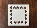 Closeup shot of white square blank paper which was punched in heart shape Royalty Free Stock Photo